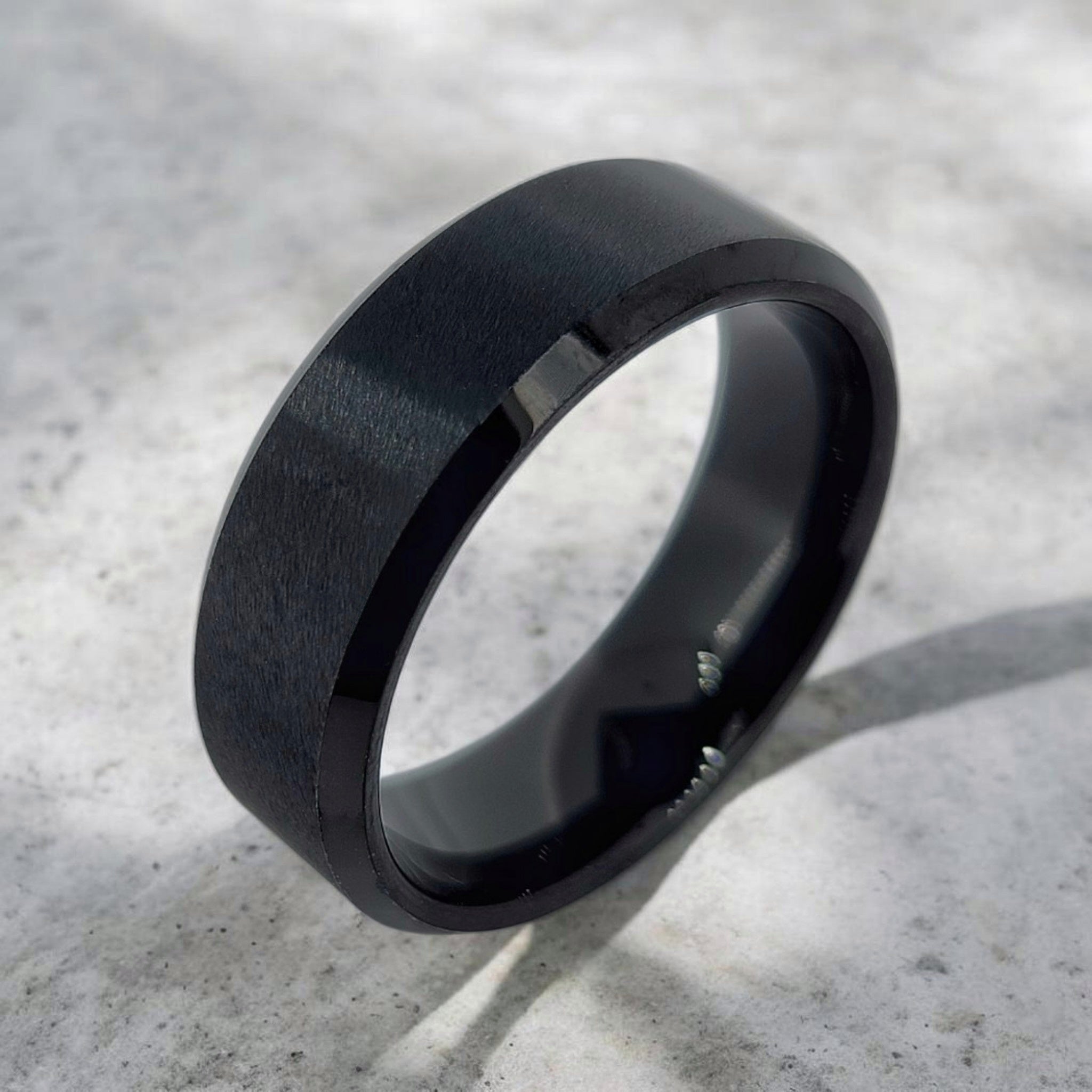 Angled view of black tungsten ring highlighting beveled edges and profile