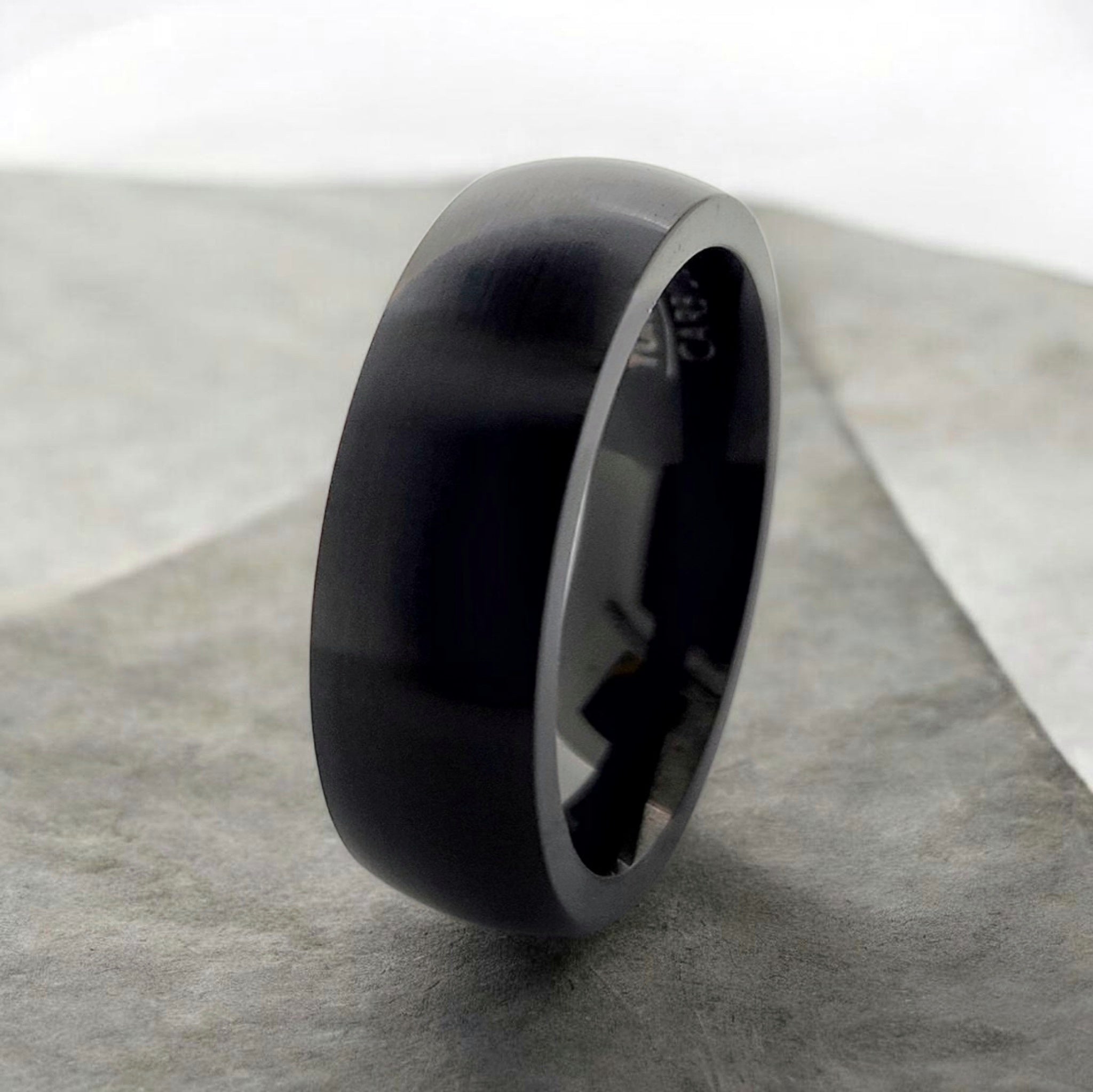Angled view of black domed tungsten ring highlighting smooth profile and matte finish
