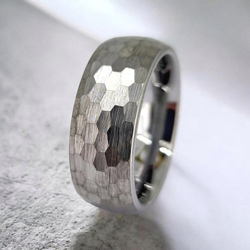 Angled view of gunmetal tungsten ring highlighting hammered finish and rugged texture