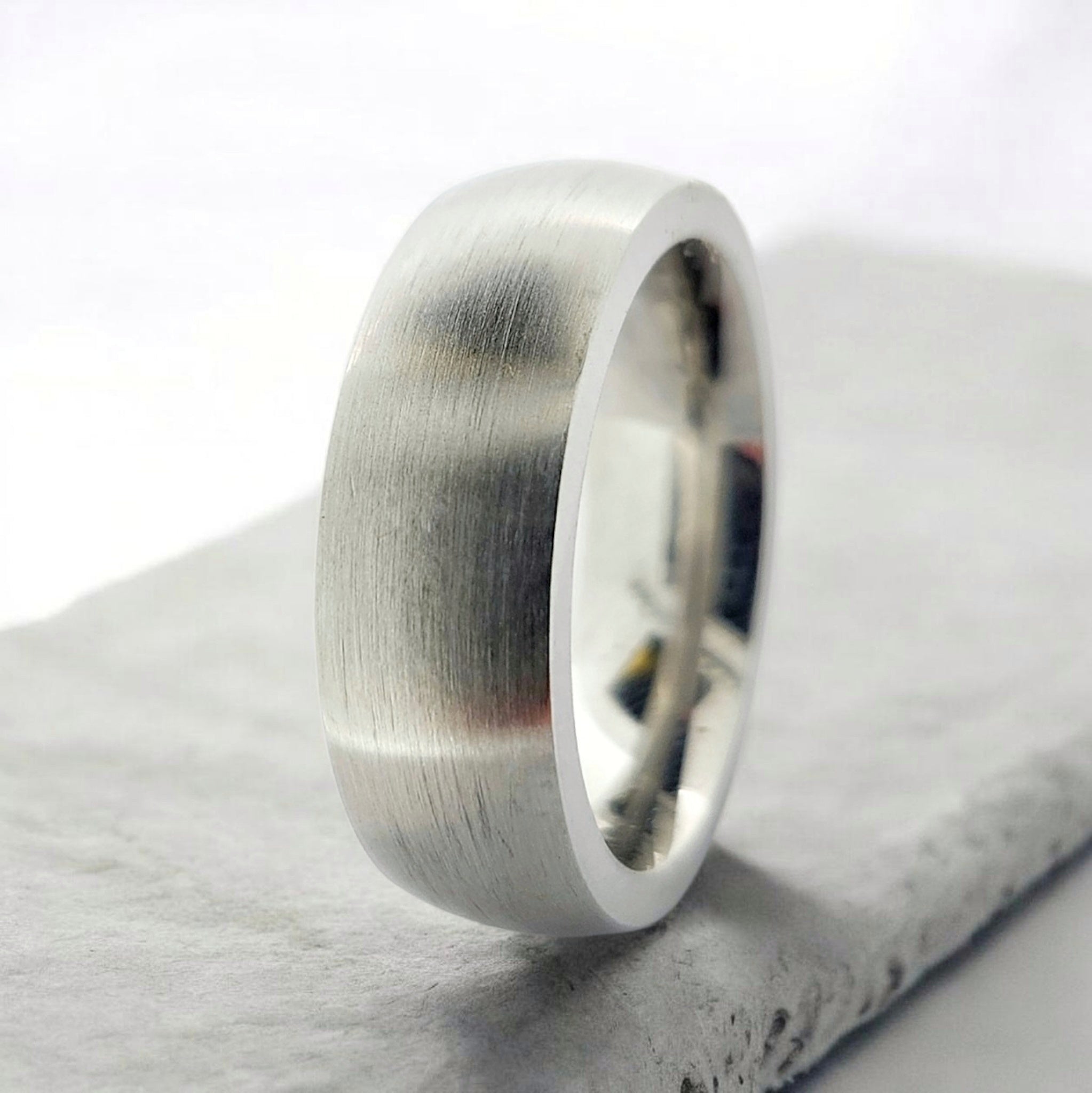 Angled view of silver domed tungsten ring highlighting smooth profile and matte finish